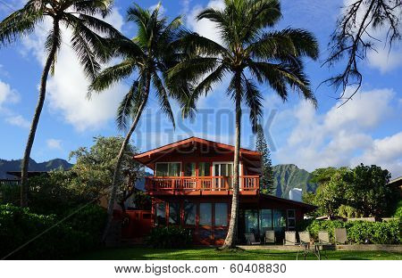 Red Two Story Beach House With Tall Coconut Trees