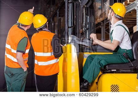 Worker Operating Forklift In Warehouse