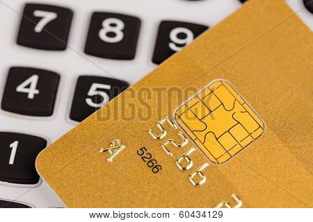 a gold credit card and a calculator. symbolic photo for cashless purchases and status symbols.