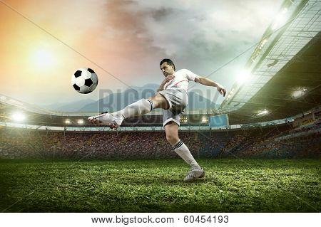 Soccer player with ball in action at stadium.