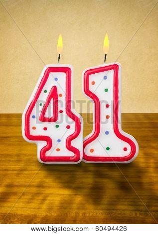 Burning birthday candles number 41 on a wooden background