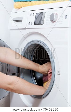 Hands Putting Laundry Into The Washing Machine Drum