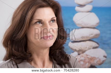 Relaxed And Happy Older Woman Portrait With A Stag Of Blue Stones.