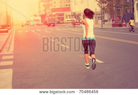 Runner athlete running on city street. woman fitness jogging workout wellness concept.