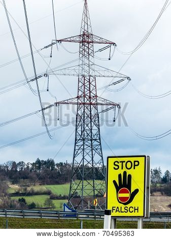 a poles of a power line and a stop sign. symbolic photo for phasing out nuclear power
