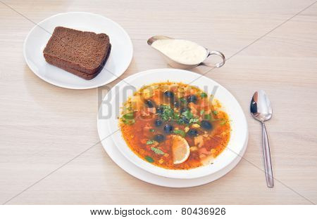 Solyanka - Thick Soup With Different Types Of Meat, With Sour Cream, Lemon And Bread