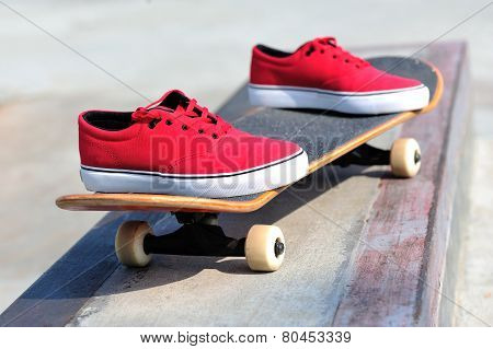 skateboard and sneakers at skatepark