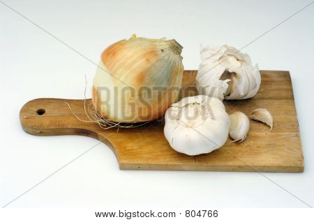 Knoblauch und Zwiebel auf einer hölzernen Platte