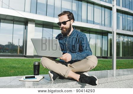 Businessman In Sunglasses With Laptop Outdoors In Front Of Office