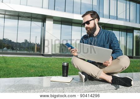 Businessman In Sunglasses With Laptop Making Call Outdoors