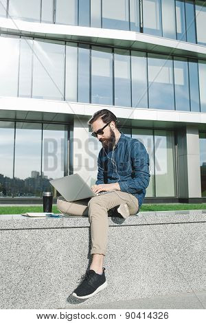 Businessman In Sunglasses With Laptop Outdoors In Front Of Office