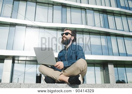 Businessman In Sunglasses With Laptop Outdoors In Front Of Office