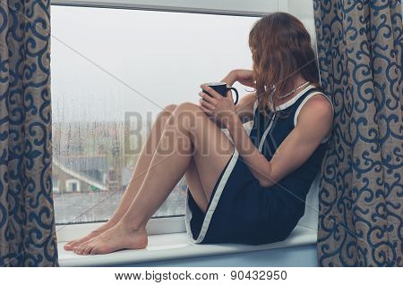 Woman Sitting On Window Sill