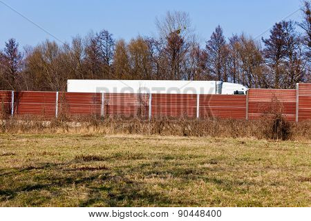 a noise barrier protects against the noise of a passing truck.