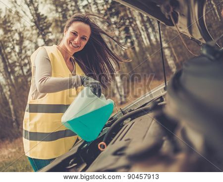 Woman adding washing fluid on a roadside