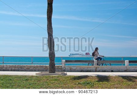 Woman riding a bike along the Paseo Maritimo