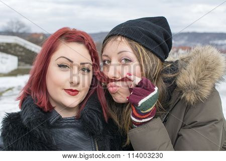 Two Girls Posing For A Funny Portrait In Winter