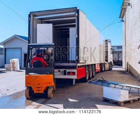 Worker On The Loader Loads Long White Semi-trailer