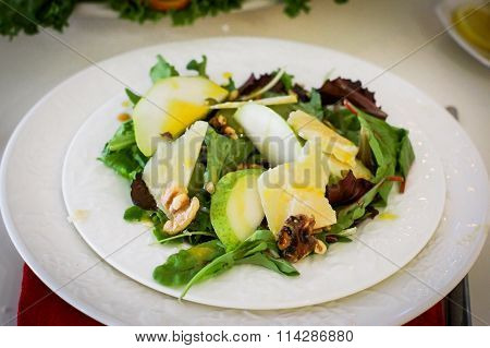 Salad With Pears, Walnuts And Cheese On White Plates
