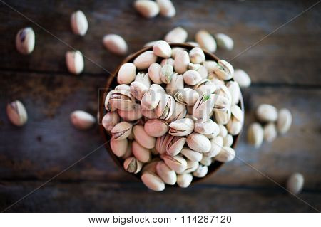Close-up Of Roasted Pistachios On Wooden Background