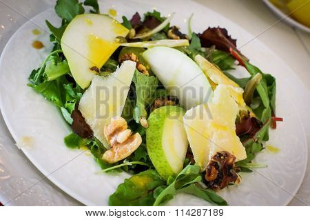 Salad With Pears, Walnuts And Cheese On White Plates