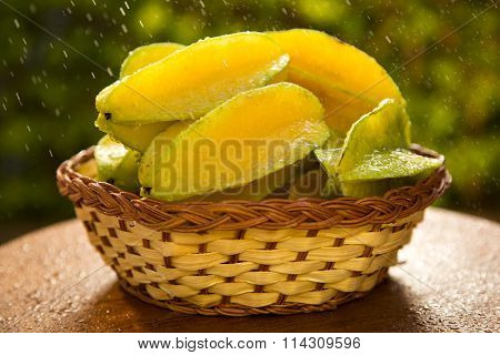 Some Caramboles In A Basket Over A Wooden Surface