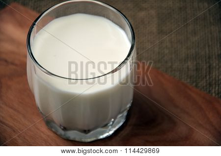 A Glass Of Milk On Wooden Board On A Background Sacking, Burlap,