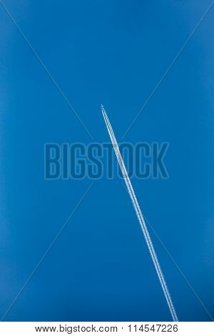 Airplane In Sky With Plane Trails