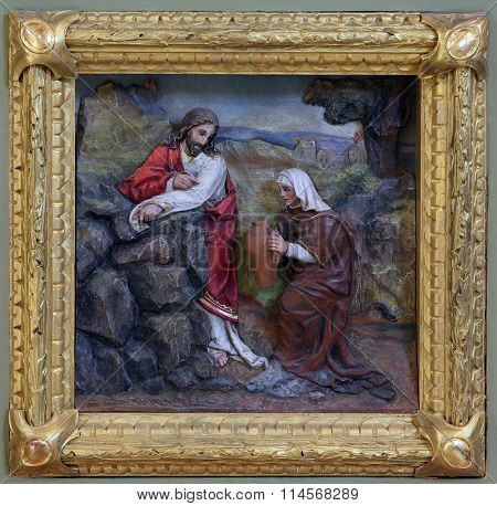 STITAR, CROATIA - AUGUST 27: Jesus and the Samaritan woman, relief on the baptismal font in the church of Saint Matthew in Stitar, Croatia on August 27, 2015