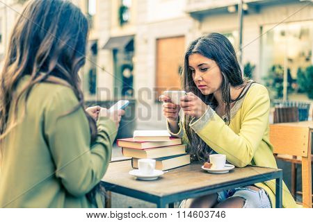 Women With Smartphones In A Bar