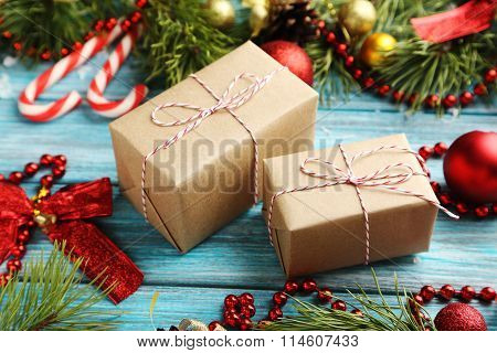 Christmax Tree Branch With Baubles And Gift Boxes On Blue Wooden Table