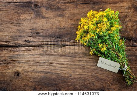 Hypericum perforatum or St john's wort with a tag on wooden background