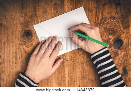 Woman Writing Recipient Address On Mailing Envelope