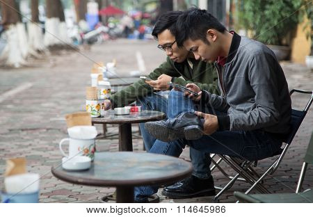 Asian people drinking coffee on the sidewalk