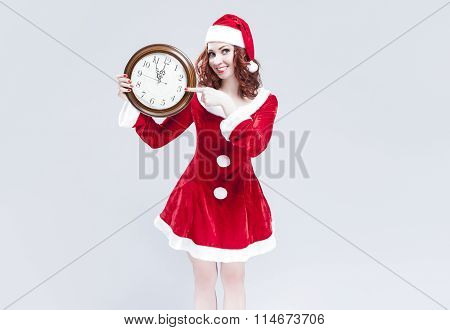 Time Concept And Ideas. Gleeful Red-haired Santa Helper With Big Round Clock And Showing Time. Posin