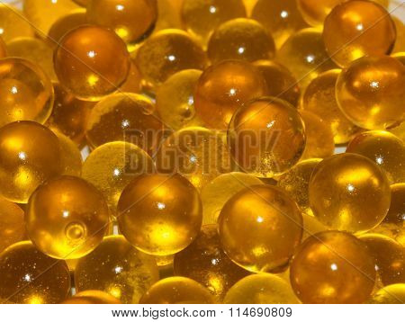 Horizontal texture yellow translucent round Golden balls. Fish ROE, fish oil. Closeup