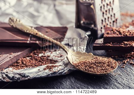 Chocolate. Black chocolate. A few cubes of black chocolate. Chocolate slabs spilled from grated choc