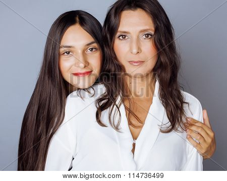 cute pretty teen daughter with mature mothr hugging, fashion style brunette