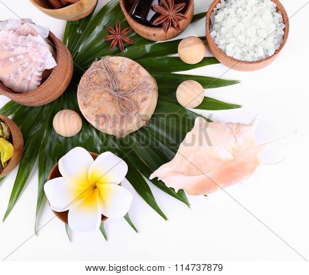 Beautiful spa setting on palm leaf, isolated on white