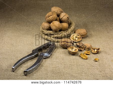walnuts and a nutcracker on a table covered with burlap