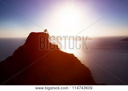 Climber giving hand and helping his friend to reach the top of the mountain. Help, support, assistance, teamwork in a dangerous situation concepts