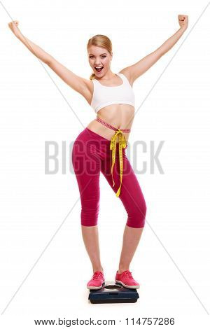 Woman Measuring On Weighing Scale With Raised Arms