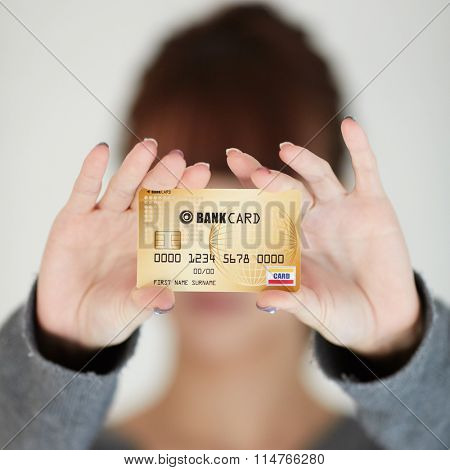 A beautiful woman holds out a business or credit card