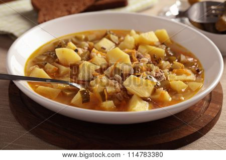 Traditional Russian soup rassolnik with pickled cucumbers on a plate