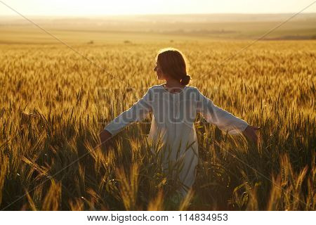 Happy Young Woman Among Field At Sunset