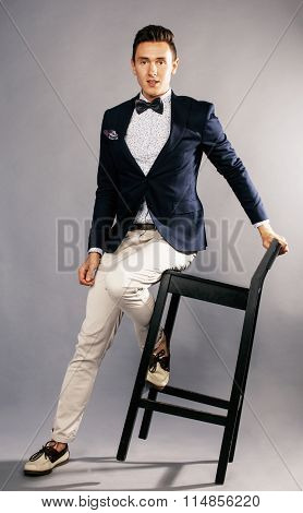 young handsoman businessman fooling aroung with chair