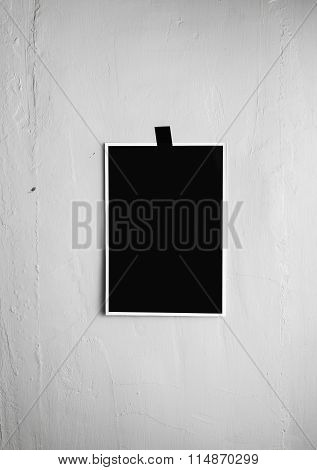 Blank Black Poster Hanging On A Tape On The Wall. Template Backg