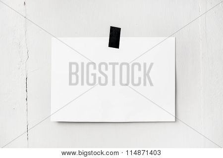 Blank White Poster Hanging On A Tape On The Wall. Template Backg