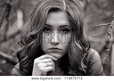Black-and-white portrait of young, very-very upset with wavy hair person, girl. She has lots of problems,and she doesn't know what to do. She all the time thinks, she is very hurt, gloomy, killed, sorrowful