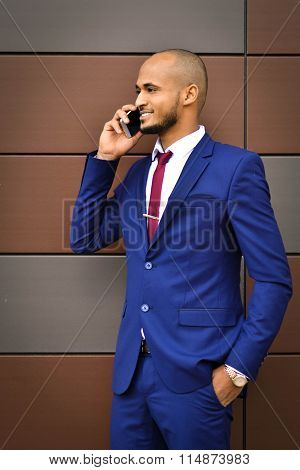 African important, young, successful, smiling businessman speaks on cell phone, gives very important, necessary advice, leaning on the wealth of experience, office, close up, leader, style, forbes, executive, boss.